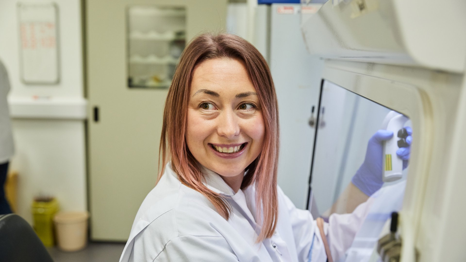 Our approach to diabetes research - a scientist smiling whilst working in a lab