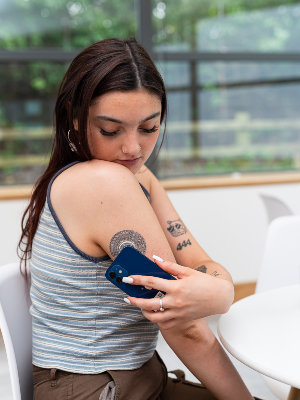 The image shows a girl wearing a Free Style Libre on her arm.