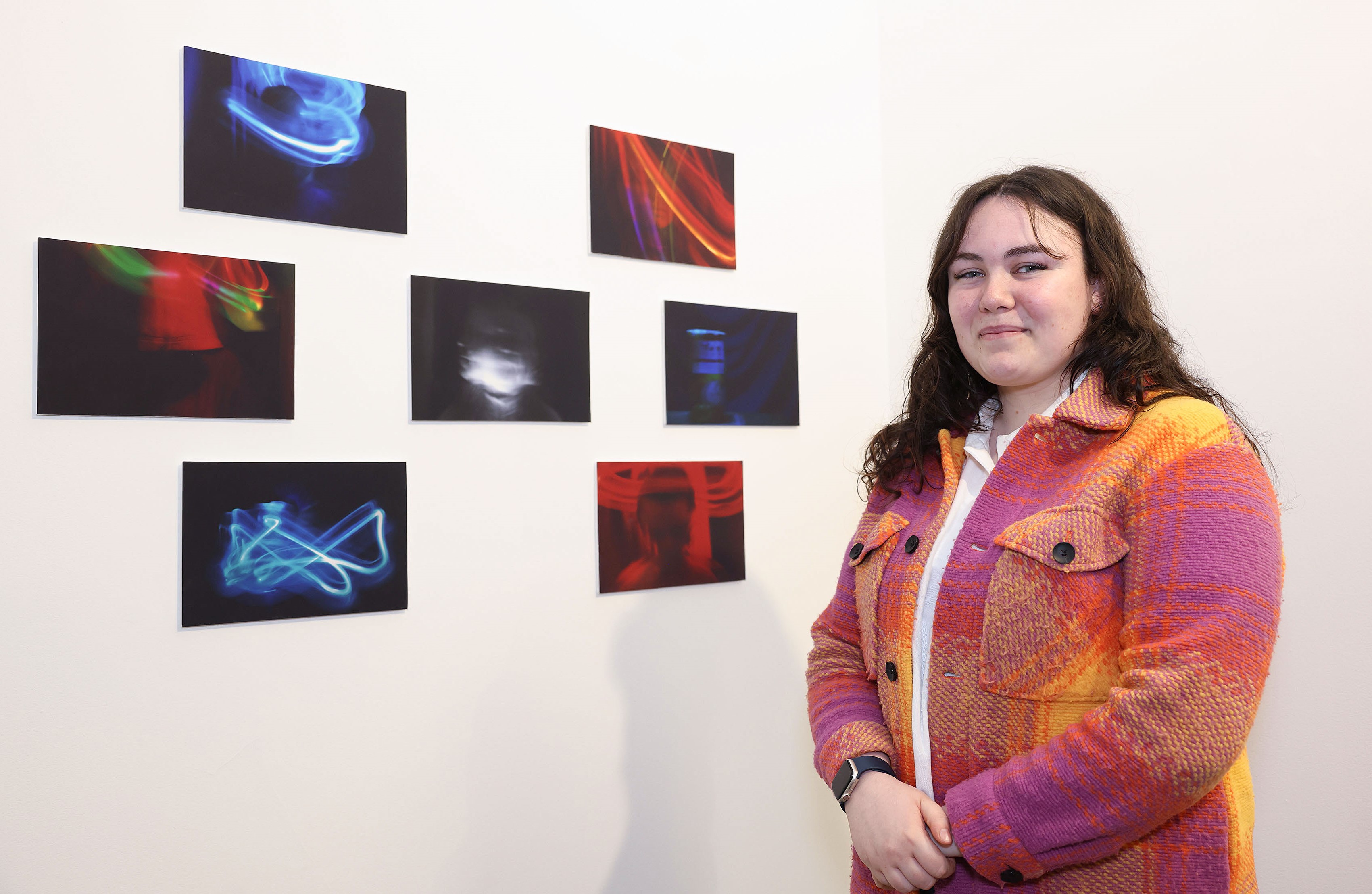 Natasha, a Young Leader from Our Lives Our Voices youth programme, standing in front of her photography project, 