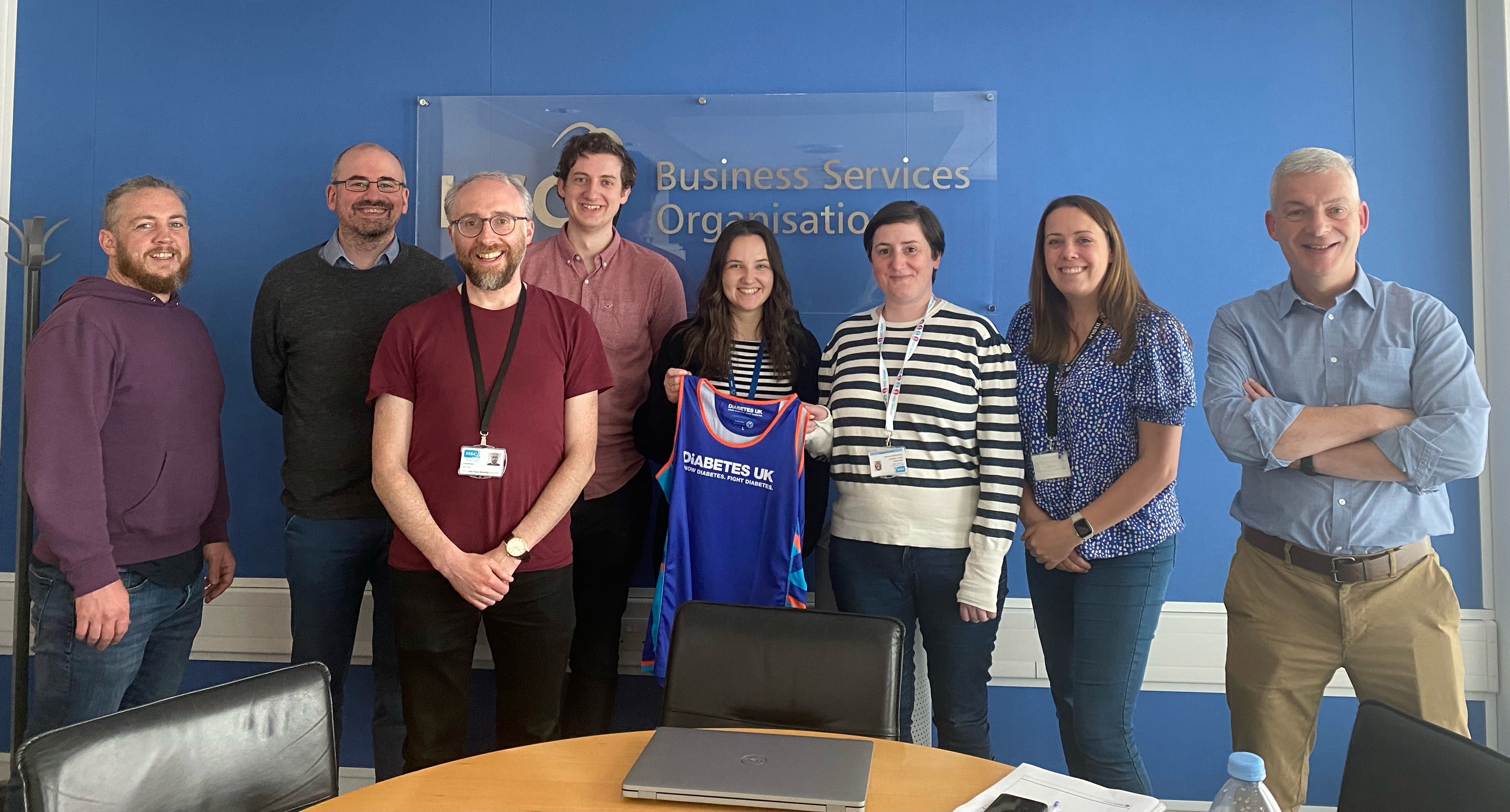 Elaine and colleagues holding Diabetes UK running shirt 