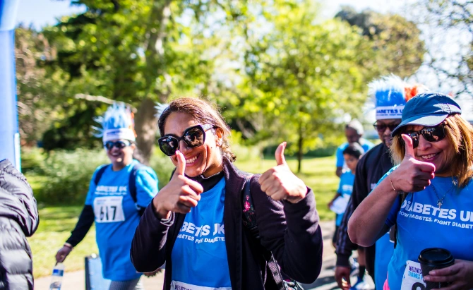 A group of Diabetes UK supporters smile with their thumbs up towards the camera. They are wearing blue Diabetes UK t-shirts.