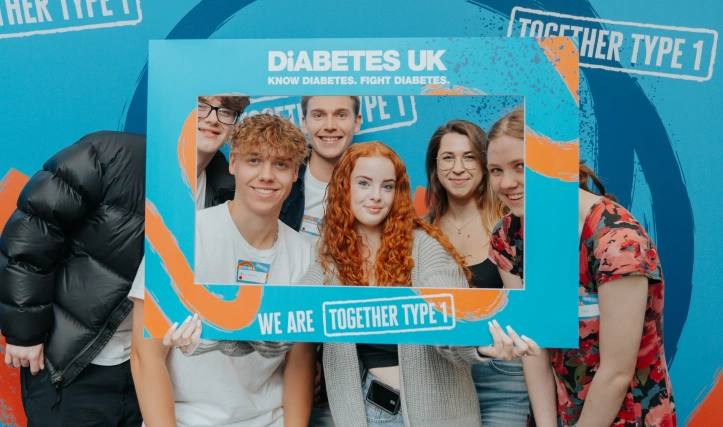 A group of young people smiling at the camera through a Together Type 1 frame.