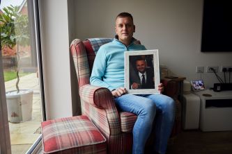 Man sitting down and holding photo frame 