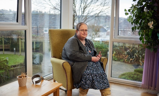 Woman sitting down in front of window