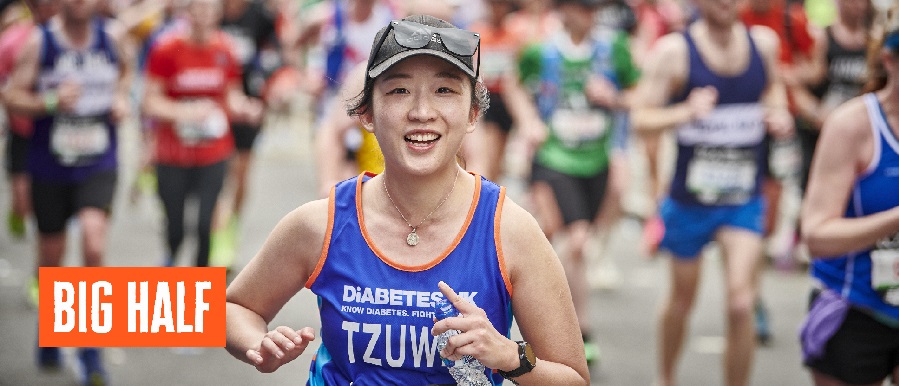 Female runner smiling to the camera in Diabetes UK Vest