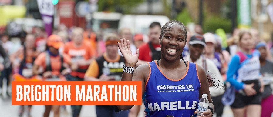 Female Runner in Diabetes UK vest smiling and waving at the camera.