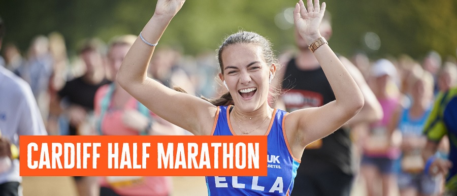 Female runner with arms outstretched in a Diabetes UK running vest.