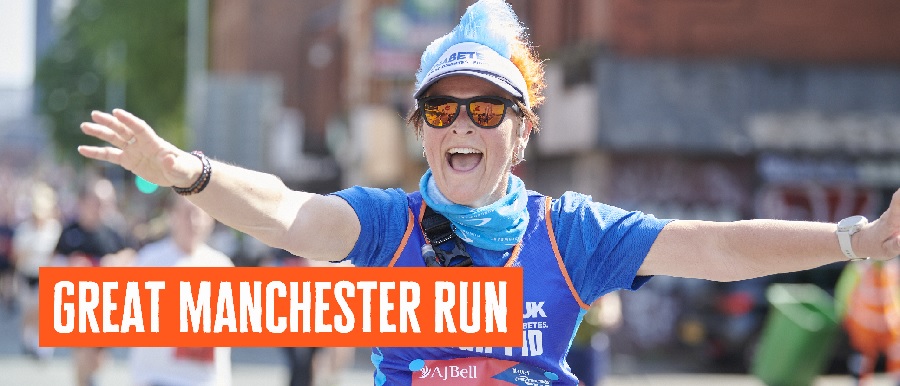 Female runner with arms outstretched in a Diabetes UK running vest.