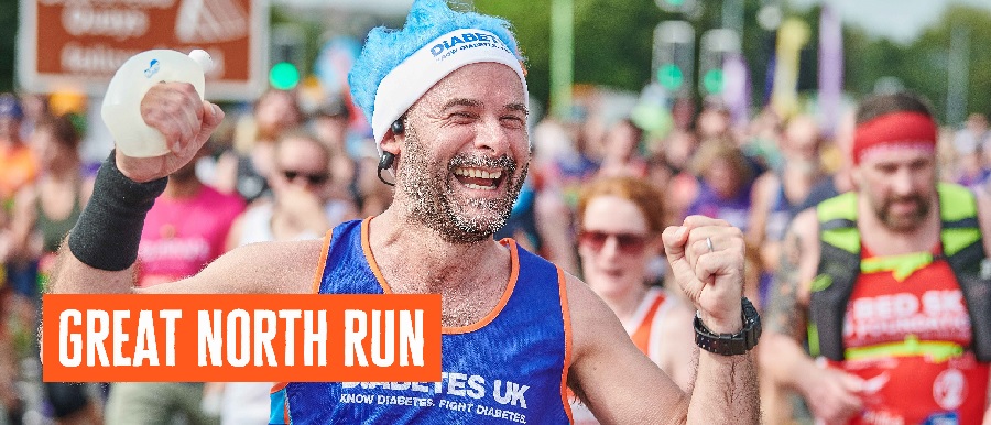 Male runner cheering to crowd in Diabetes UK running vest.