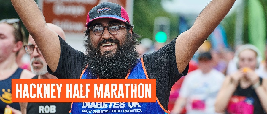 One man has hands in the air with Diabetes UK vest on and a cap.