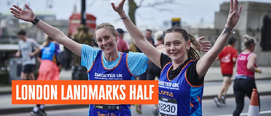 Two female runners in Diabetes UK Vests with arms outstretched, smiling.