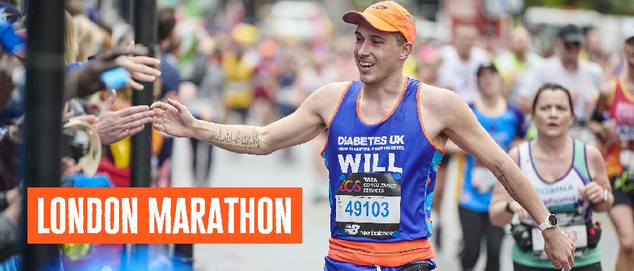 Male runner cheering to crowd in Diabetes UK running vest.