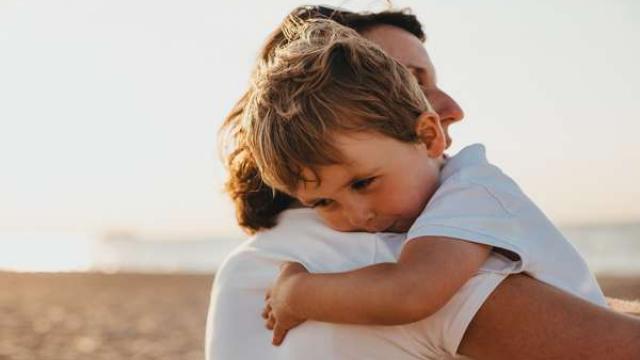 A young child living with diabetes being carried by his parent