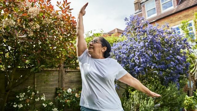 Riffat practicing a yoga pose in her garden as she gets moving at home 