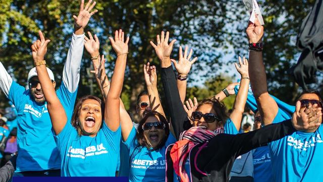 A group of people wearing blue Diabetes UK tshirts, cheering