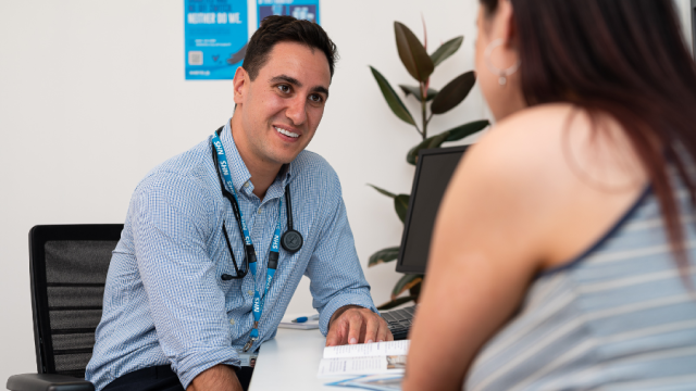 The image shows a male doctor speaking to a lady. 