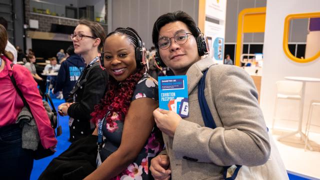 two people smiling at camera holding a conference pass