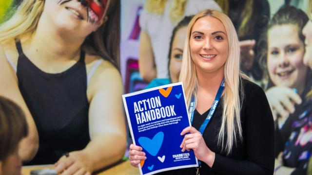 Health Psychologist holding up copy of the AcT1on handbook