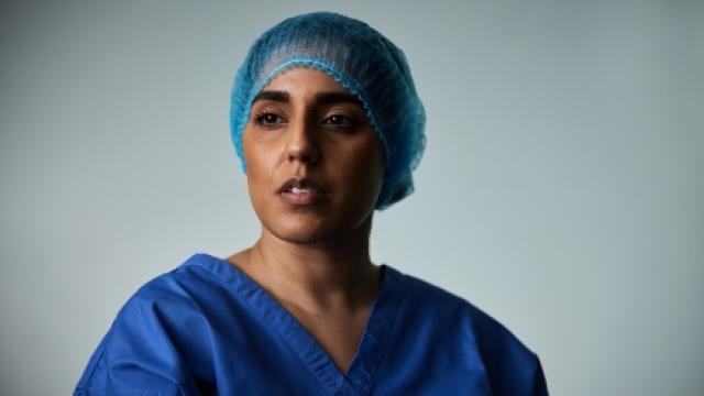 A head shot of a surgeon in her scrubs looking past the camera