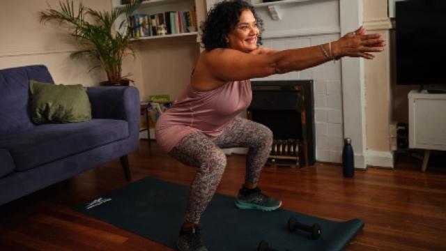 A woman doing squats in her living room