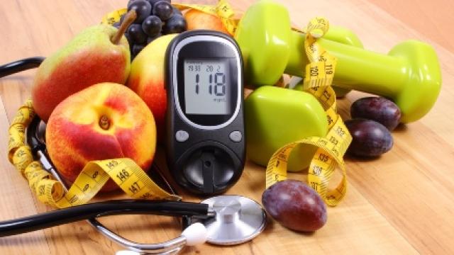 A blood test monitor surrounded by fruit and gym equipment