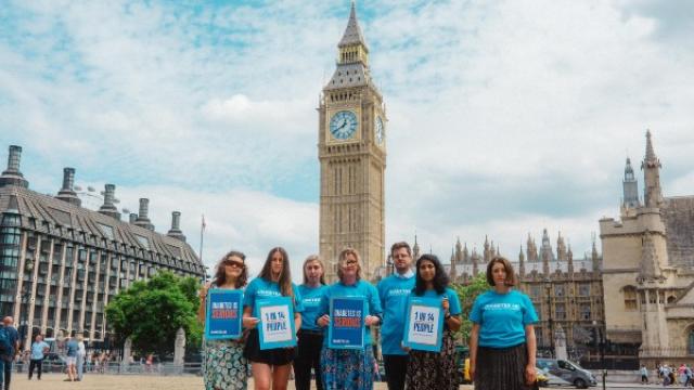 Group of people wearing Diabetes UK t-shirts stand in front of the houses of parliament