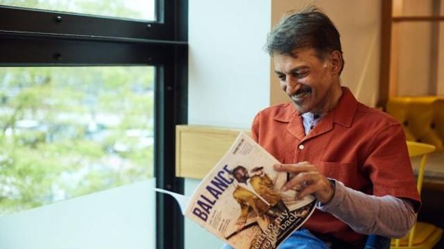 Abdul sat down smiling reading the membership magazine, Balance