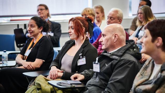 A group of people listening to a talk