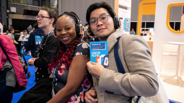 two people smiling at camera holding a conference pass