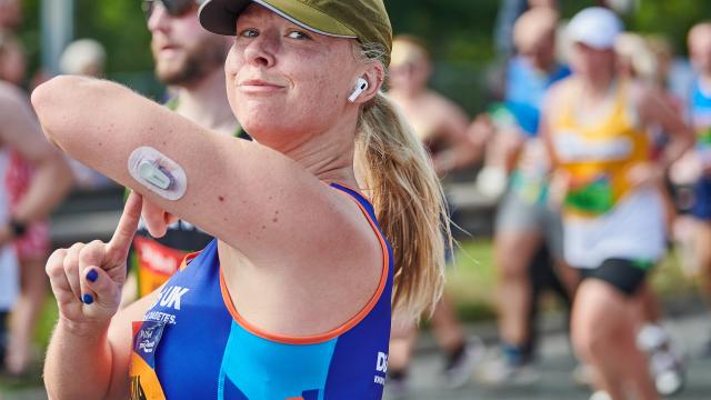 A female runner pointing to diabetes tech.