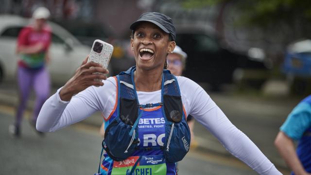 Female runner with phone smiling at camera