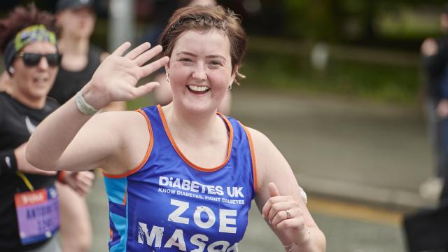 Female runner in Diabetes UK vest waving at the camera.