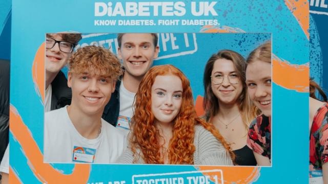 Group of young people hold smiling while holding a Together Type 1 frame