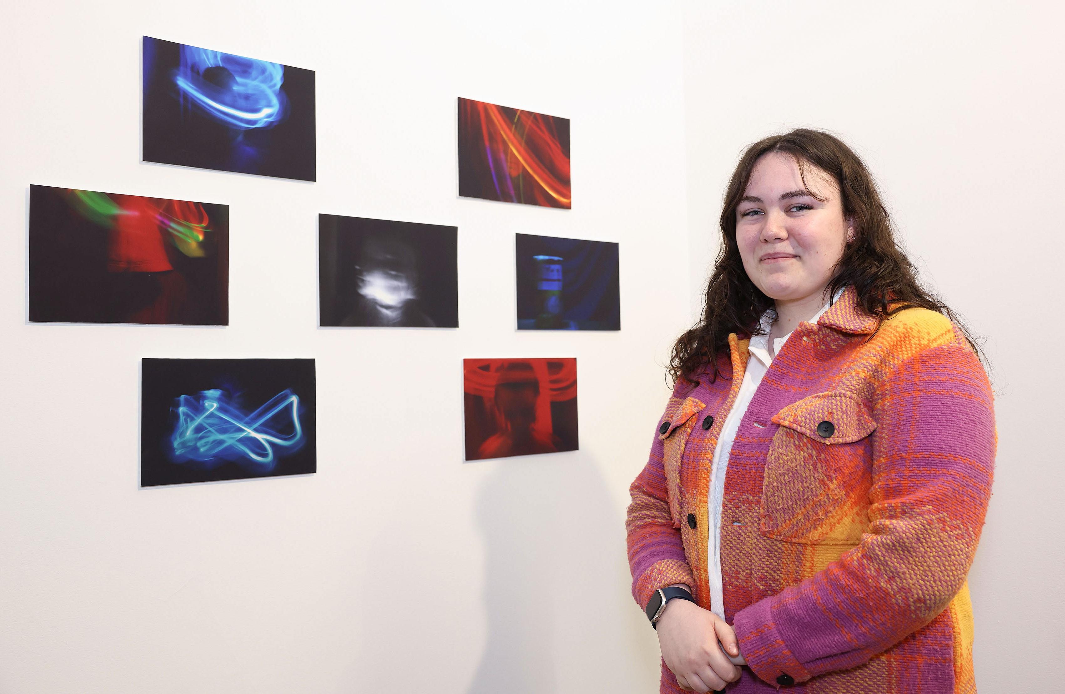Natasha, a Young Leader from Our Lives Our Voices youth programme, standing in front of her photography project,