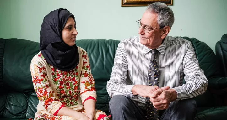 A man and a woman sat on the sofa chatting