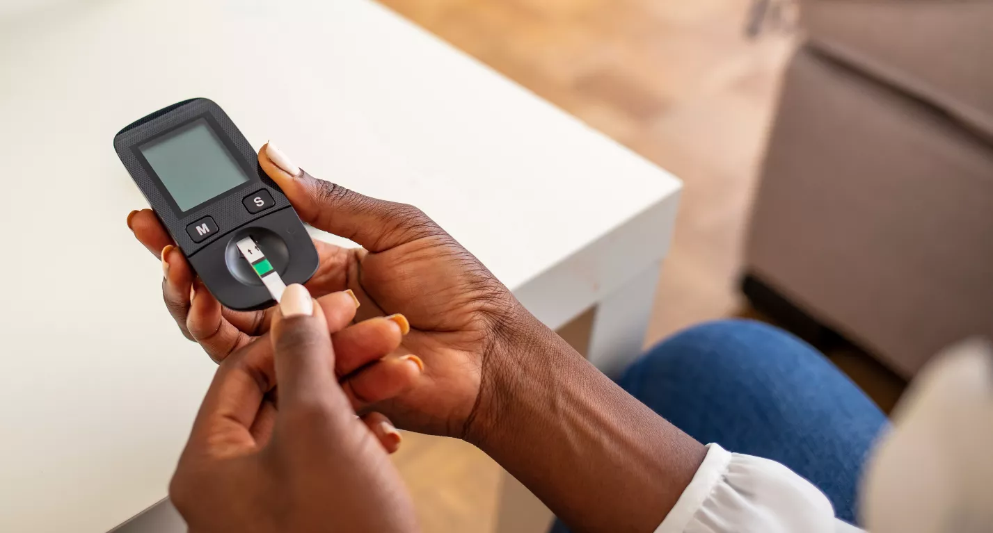 Woman hands using lancet on finger to check blood sugar level