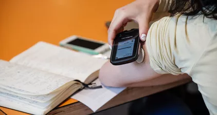 Someone holds a monitor against their arm