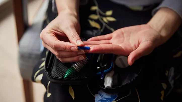 Woman pricking her finger to check blood sugar levels