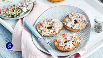 Mini salmon bagels on a plate with a knife