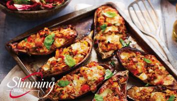 Stuffed baked aubergines on an oven pan with a spatula to the left