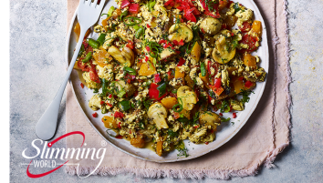 A plate of spicy tofu scramble with a fork lying next to it