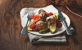 A plate of aubergine meatballs and tomato sauce with courgettes