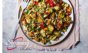 A plate of spicy tofu scramble with a fork lying next to it