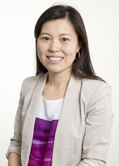 Woman smiling wearing cream blazer against white background